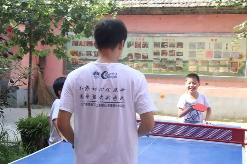 開心地跟老師打乒乓球的孩子