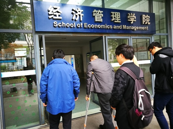 侯劍老師在學生幫助下上樓梯