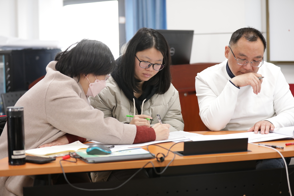 張琴（左一）與焦佳佳副教授（左二）在試點(diǎn)班培訓(xùn)現(xiàn)場研討教學(xué)案例