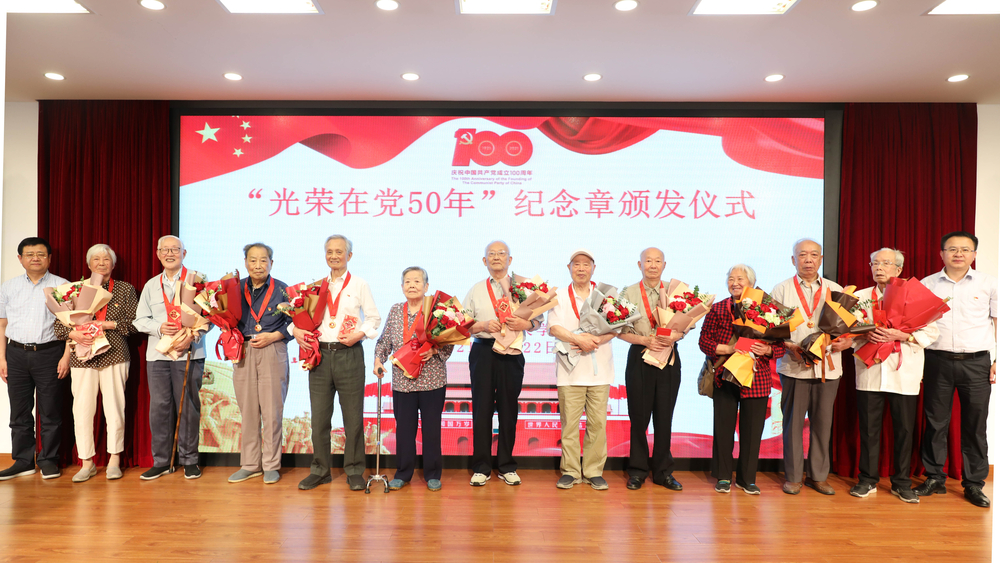 校領(lǐng)導(dǎo)為退休黨員頒發(fā)紀(jì)念章、獻(xiàn)花并合影留念