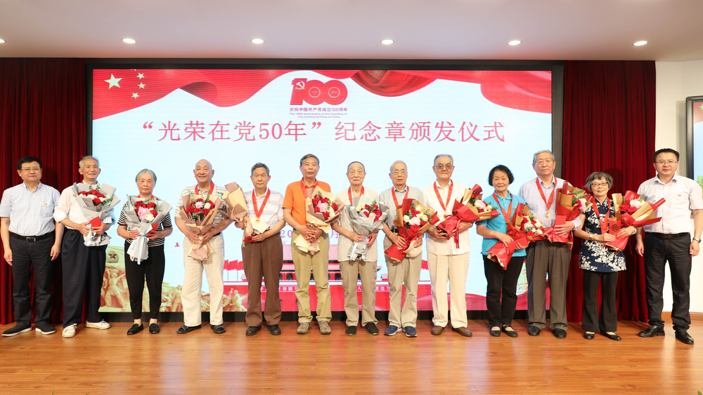 校領(lǐng)導(dǎo)為退休黨員頒發(fā)紀(jì)念章、獻(xiàn)花并合影留念