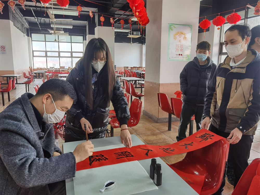 李志鵬與留校學生一起寫春聯.